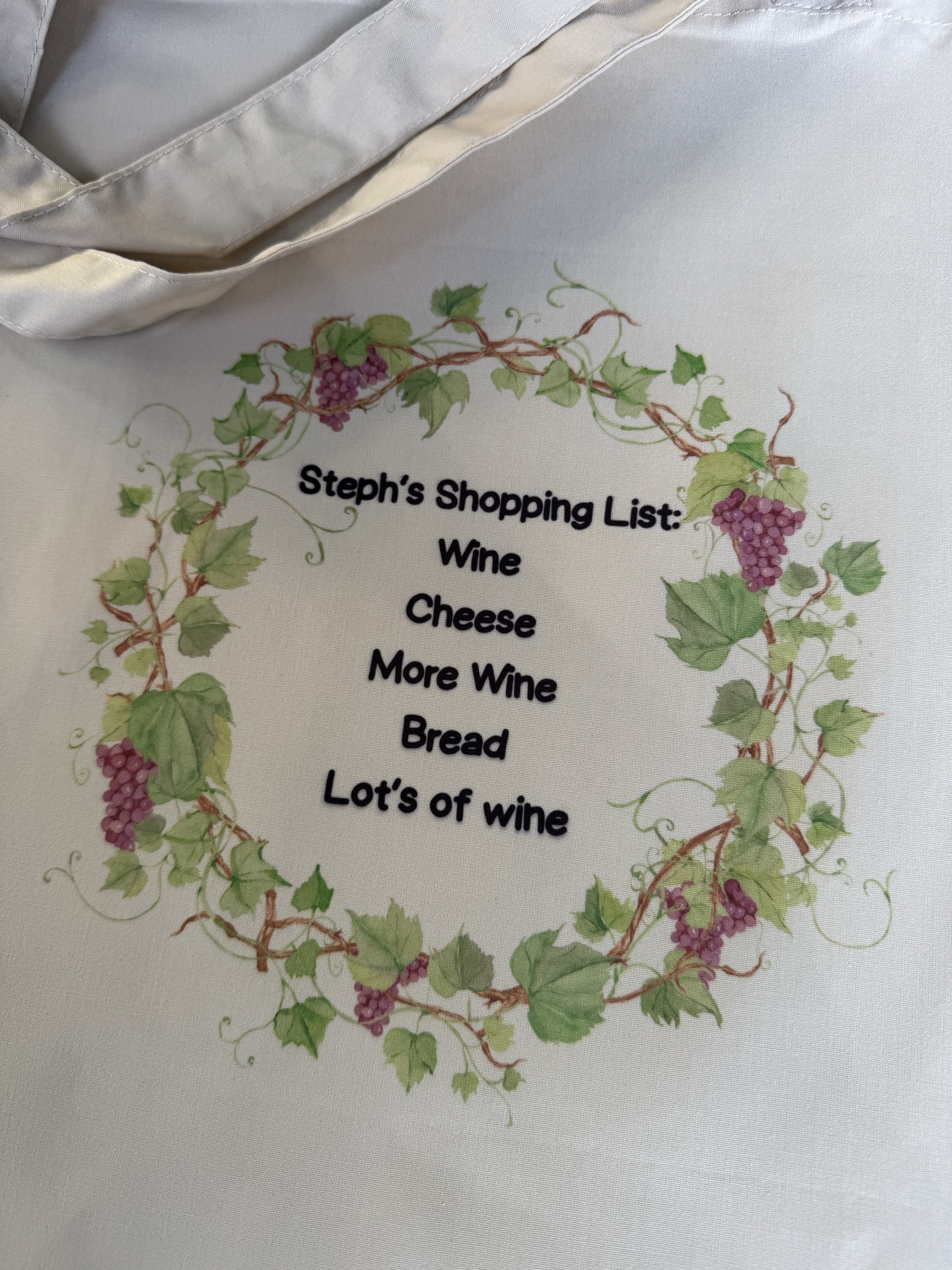 Tote bag with wine shopping list text.'